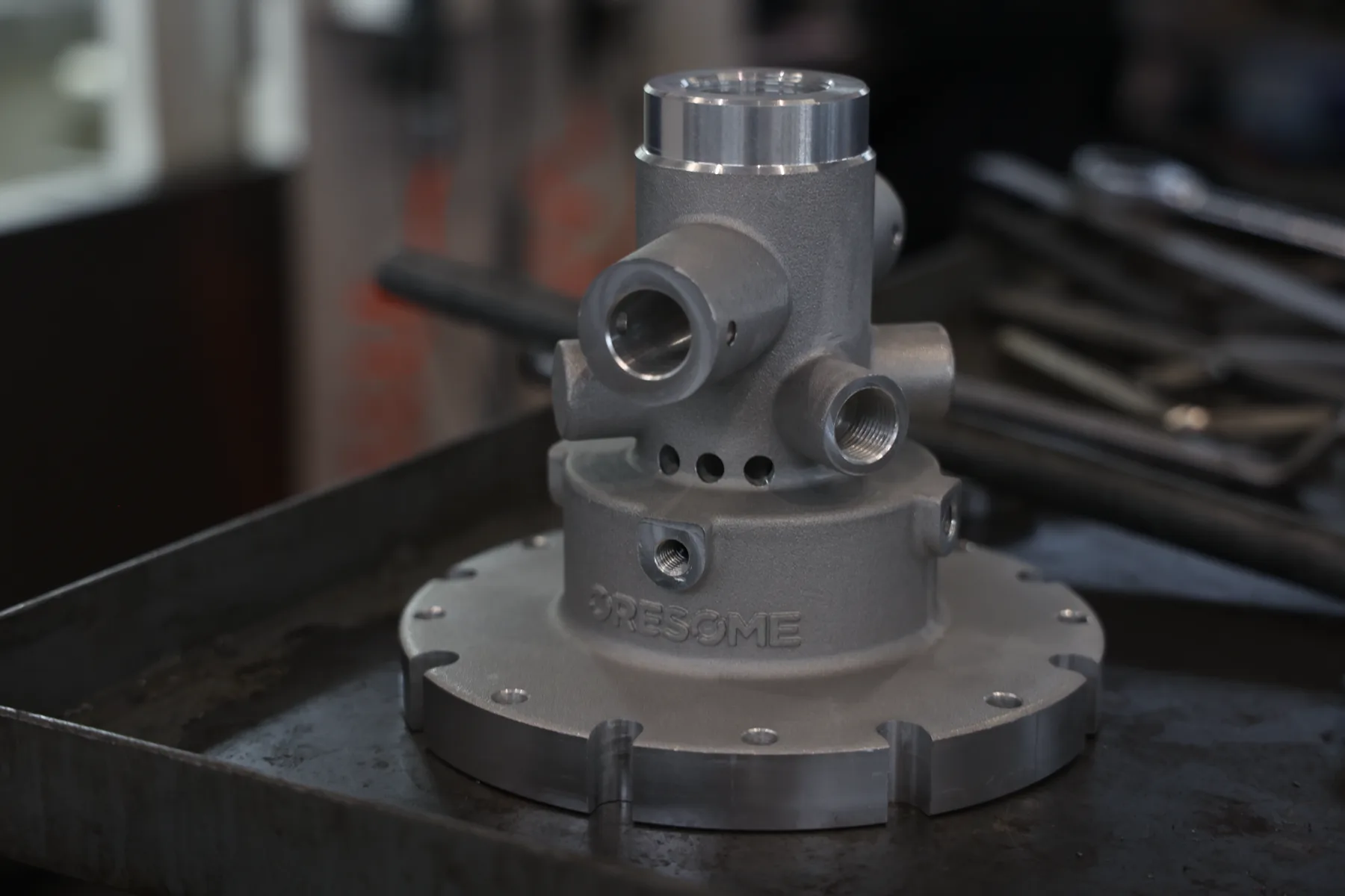 Close-up of a cast metal pump head with ORESOME cast directly into the flange.
